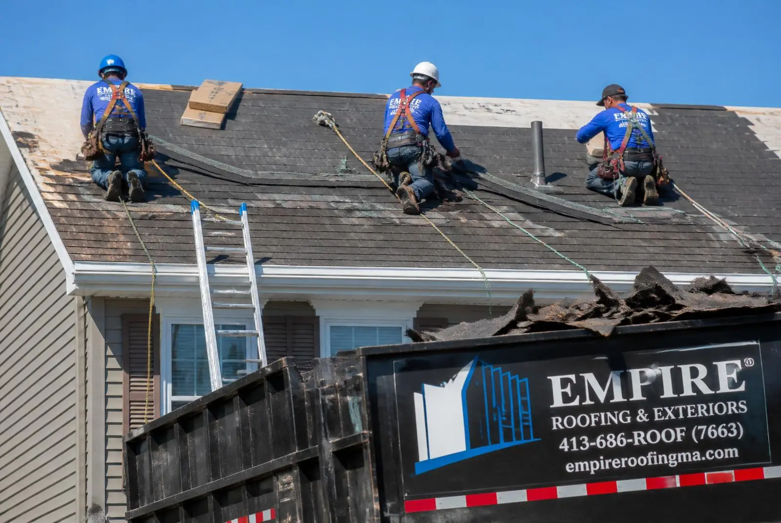 A roofing crew working on a residential roof on a job site